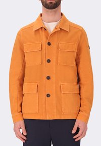 Giacca in cotone arancione con chiusura a bottoni, due tasche sul petto e due tasche inferiori. Presenta un colletto classico e bottoni neri.