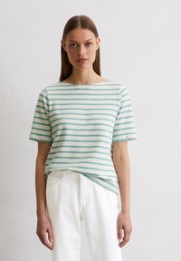 Gestreiftes Baumwoll-T-Shirt mit einem Bootsausschnitt, das in hellen Türkis- und Off-White-Farben horizontale Streifen aufweist, kombiniert mit weißen Jeans.