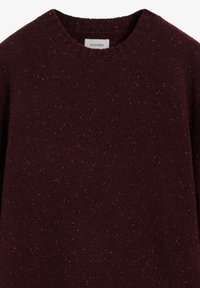 Burgunderfarbener Pullover mit Rundhalsausschnitt, strukturierter Stoff mit roten und goldenen Sprenkeln. Das Etikett am Kragen trägt die Aufschrift "SCALPERS".