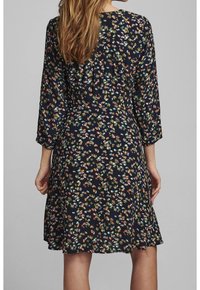 Robe à imprimé floral en tissu bleu marine foncé ; dotée de manches trois-quarts, d'une coupe décontractée et d'un ourlet évasé avec des accents floraux multicolores.
