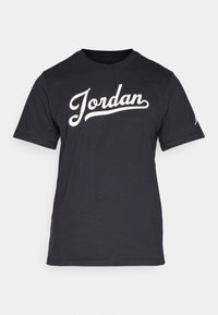 Czarny bawełniany t-shirt z krótkim rękawem. Na przodzie widnieje duży napis "Jordan" w białej, kursywnej czcionce oraz detal z logo na rękawie.