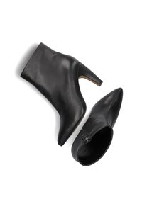 Zwarte leren enkelboots met een spitse neus, hoge blokhak, gladde afwerking en een ritssluiting aan de zijkant. Platte zool met lichtbruine accenten.