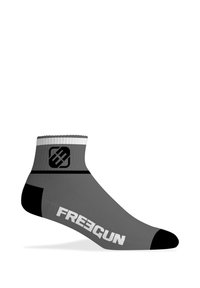 Chaussette grise au niveau de la cheville avec des accents blancs et noirs, arborant un design de logo sur le revers et un texte en gras "FREEGUN" sur le côté.