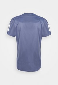 Camiseta deportiva azul con una textura suave, cuello redondo y mangas cortas, con rayas blancas contrastantes en el hombro.