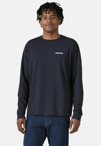 Ναυτικό μπλουζάκι μακρυμάνικο από βαμβάκι, με στρογγυλή λαιμόκοψη και μικρό λευκό λογότυπο Patagonia στο αριστερό στήθος. Λείος υφή.