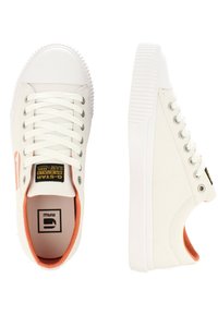 Baskets en toile blanches avec une semelle en caoutchouc, bout arrondi et accents orange. Elles présentent des lacets plats et un patch logo sur la languette.