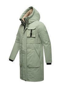 Parka izolată de un verde deschis, cu guler înalt, căptușeală pufoasă, multiple buzunare și accente negre pe manșete și închiderea frontală.