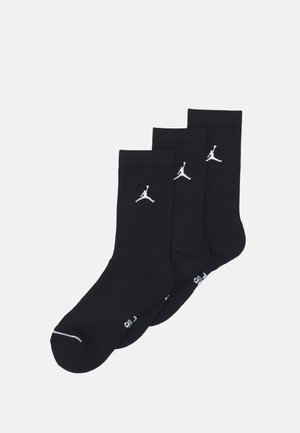 Črne bombažne nogavice, pakirane v trojčku, z ribastim vzorcem in belim Jumpman logotipom na strani. Gladka površina z ojačanimi peto in prsti.