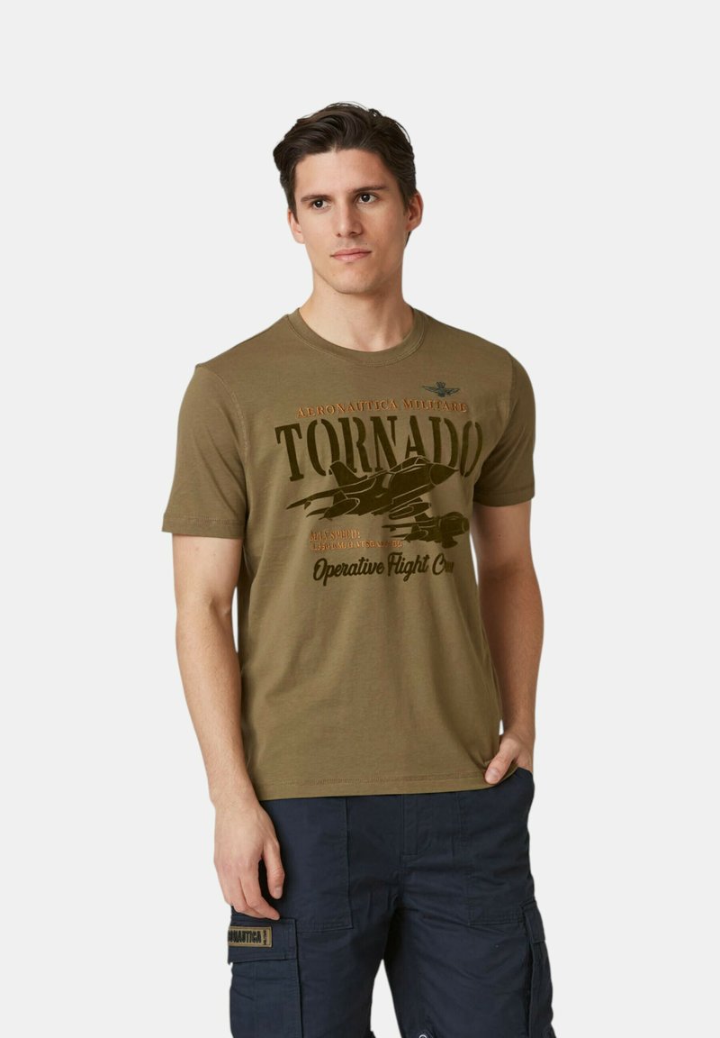 T-shirt in cotone verde oliva con grafica di un aereo nero e testo marrone, colletto rotondo, maniche corte e una vestibilità attillata.
