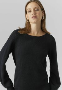 Maglione nero, morbido, con scollo rotondo e maniche lunghe. Presenta un design minimale e una texture liscia, adatto per un abbigliamento casual.