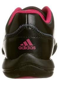 Czarne buty sportowe z gładką skórzaną cholewką, różowymi akcentami i logo Adidas. Posiadają wyściełany obcas i teksturowaną podeszwę dla lepszej przyczepności.