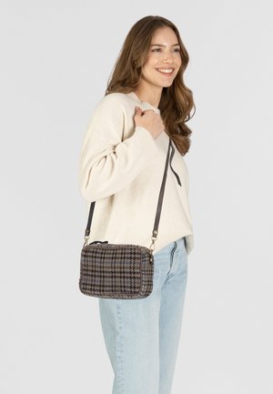 Brown and blue checkered crossbody bag with a zipper, structured shape, fabric texture, and adjustable brown strap.