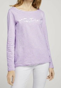 Långärmad lila randig tröja med vid halsringning, prydd med vit text fram. Mjuk tygkvalitet med avslappnad passform och sidslitsar.