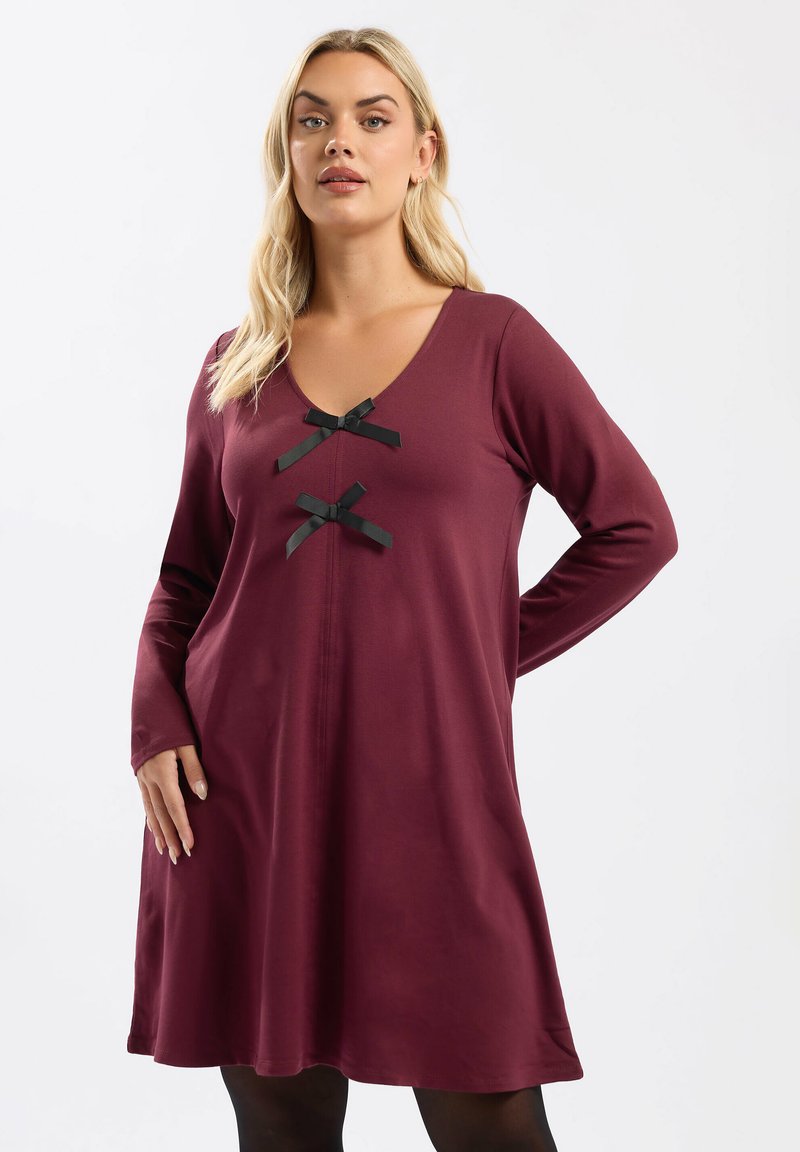 Vestido largo burdeos de manga larga con escote en V, dos acentos de cinta negra y un corte A fluido, hecho de una tela suave y lisa.