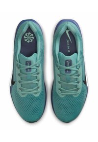 Zapatillas deportivas turquesas con parte superior de malla, puntera redondeada, logo Swoosh negro y acentos azules. Cuenta con seis agujeros para los cordones y lengüeta acolchada.