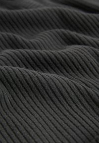 Tissu noir côtelé avec une texture douce, présentant des rainures verticales régulièrement espacées. Le matériau semble léger et souple.