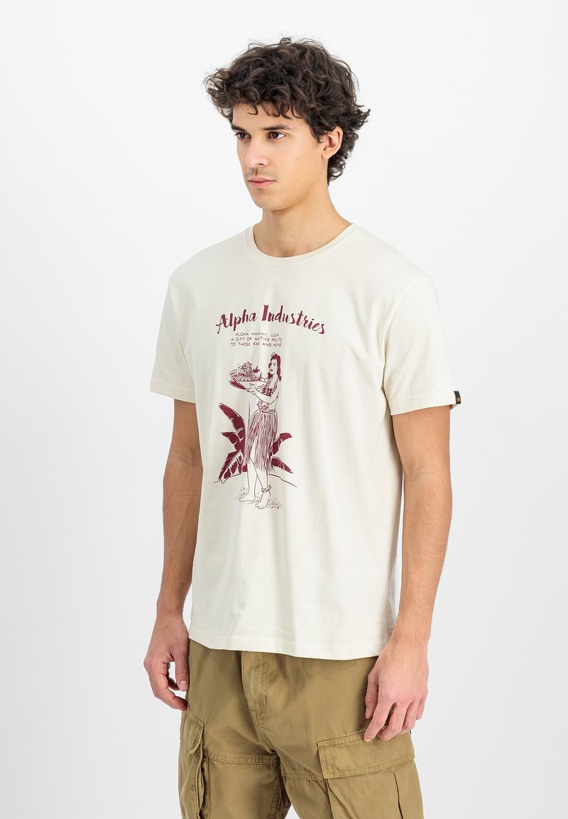 Heledbeesist puuvillane T-särk, millel on burgundia värvi graafiline print, kus on kujutatud kuju, kes hoiab kotti, ja peal on tekst "Alpha Industries".