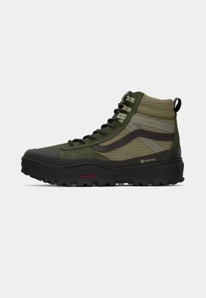 Hoge wandelschoenen in olijfgroen en kaki gaas. Voorzien van een zwarte rubberen zool, GORE-TEX-label en versterkte randen voor duurzaamheid.