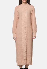 Lange roze gebreide trui-jurk met een textuur van kabelpatroon in het midden en geribbelde boorden en zoom.