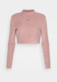 Ljusrosa, kortärmad topp med lång ärm, tillverkad av mjukt material med en hög krage och en liten svart Nike-logotyp på bröstet.