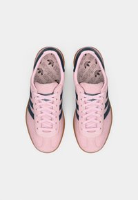 Rosa semskede joggesko med marineblå striper, gummisåle og teksturert innersåle med et gjentakende logomønster. Snøring i matchende rosa farge.