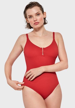 Traje de baño de una pieza rojo con costillas, con tirantes delgados ajustables, escote redondeado y un detalle de corte en forma de llave en el centro. Textura suave.
