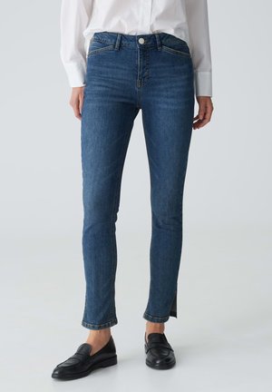 Schlanke Jeans aus dunkelblauem Denim, mit hoher Taille, fünf Taschen und dezenten Schlitzen am Saum der Knöchel.