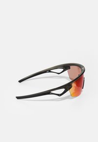 Sonnenbrille mit einem schlanken schwarzen Rahmen, geschwungenen Bügeln und rot verlaufenden Gläsern. Besitzt ausgeschnittene Designelemente und eine glänzende Oberfläche.