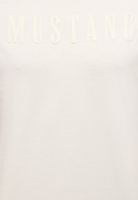 Weißes Baumwoll-T-Shirt mit geprägtem "MUSTANG"-Schriftzug in passendem Farbton, mit glatter, leichter Textur und klassischem Rundhalsausschnitt.