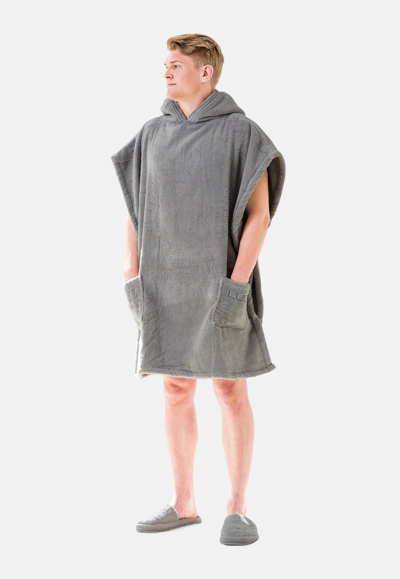 Poncho grigio con cappuccio realizzato in tessuto morbido e testurizzato; presenta due tasche frontali ed è indossato sopra le pantofole. Design regolabile per il massimo comfort.