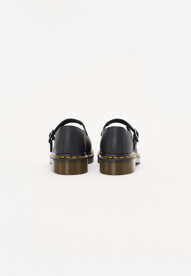 Black leather sandals with a buckle strap, featuring a chunky sole with yellow stitching and a rounded toe. Back view shows textured material.