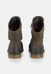 Botas de tobillo de cuero marrón con una textura suave, cierre de cremallera y forro interior en contraste. Punta redonda y tacón bajo.