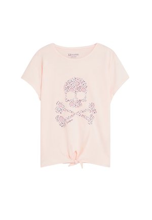 Camiseta de manga corta de color rosa claro con un diseño frontal de calavera y huesos cruzados con flores, y un pequeño nudo atado en el centro inferior.