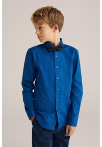 Blå knapp-up skjorta med ett texturerat mönster, långa ärmar och en svart fluga. Har knäppt fram och en klassisk kragdesign.