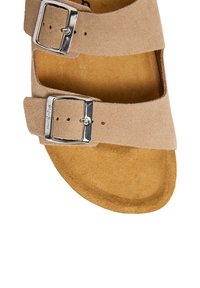 Beige semsket skinnsandal med to justerbare sølvspenner og en formet fotseng for komfort og støtte.
