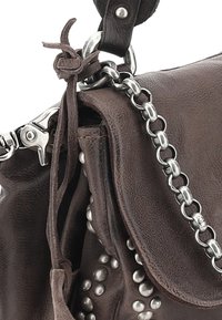 Bolso de mano de cuero marrón con un acabado texturizado, tachuelas plateadas y un acento de cadena metálica. Presenta un detalle de nudo en la correa.