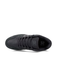 Czarne sneakersy z zamszową i syntetyczną cholewką, z okrągłym noskiem, perforacjami zapewniającymi wentylację oraz płaskimi sznurowadłami. Logo DC na języku.