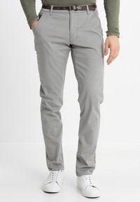 Gray, slim-fit trousers made of lightweight fabric, featuring side pockets and a smooth texture, paired with a brown belt and white sneakers.