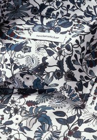 Camicia bianca con un motivo floreale in navy, teal e bordeaux. Include un'etichetta Seidensticker e due bottoni bianchi sul colletto.