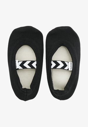 Schwarze Leinenschlupfschuhe mit einem kontrastierenden beigen Innenfutter. Verfügt über ein elastisches Band mit einem schwarz-weißen Zickzackmuster.