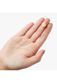 En hånd som holder en liten, gjennomsiktig, kremfarget gelé. Huden er lys og glatt, med bemerkelsesverdige detaljer inkludert synlige fingeravtrykk.