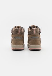 Braune Wildleder-Wanderschuhe mit pinken Akzenten, einem gepolsterten Kragen und einer Gummisohle. Die Rückansicht zeigt zwei verstellbare Riemen für einen sicheren Halt.