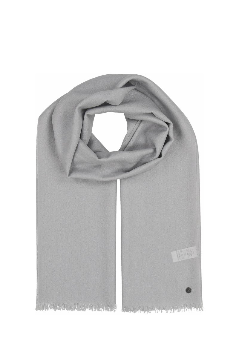 Écharpe gris clair en tissu doux avec des bords à franges, de forme ovale et portant une petite étiquette avec un logo rond.