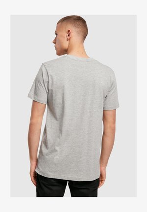 Szara bawełniana koszulka z okrągłym dekoltem i krótkimi rękawami, o miękkiej fakturze i regularnym kroju, widziana z tyłu.