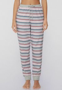 Pantalones de pijama grises con un patrón de zigzag en rosa, azul, rojo y verde. Cintura elástica con cordón y puños acanalados.