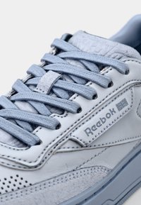 Sneaker Reebok con tomaia in pelle e suede azzurro chiaro, con dettagli testurizzati, lacci piatti e fori di ventilazione sui lati.