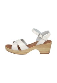 Sandalias de cuero blanco con diseño de tiras cruzadas, tacones de cuña de madera y correa ajustable en el tobillo con hebilla de metal. Textura suave.