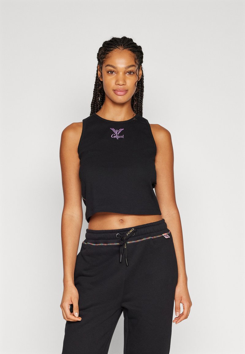 Top corto nero in tessuto morbido, con logo viola ricamato sul davanti. Abbinato a pantaloni neri e dettagli colorati con cordino.