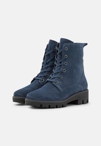 Stivali alla caviglia in suede blu scuro con design alla moda, punta rotonda e suola in gomma testurizzata con lugs visibili per una migliore trazione.