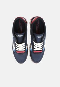 Zapatillas de navy hechas de tela con cordones blancos, con detalles en rojo y azul, suela de goma y logotipo en la lengüeta.